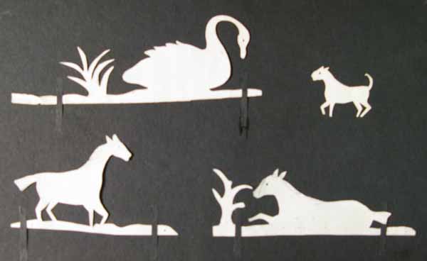 White Paper Cut Out Silhouettes of a Swan, Dog and Two Horses
