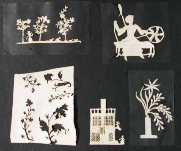 Five White Cut Out Paper Silhouettes of a Woman with Animals, a Woman with a Spinning Wheel, Flowers, Woman and House and Flowers in a Vase